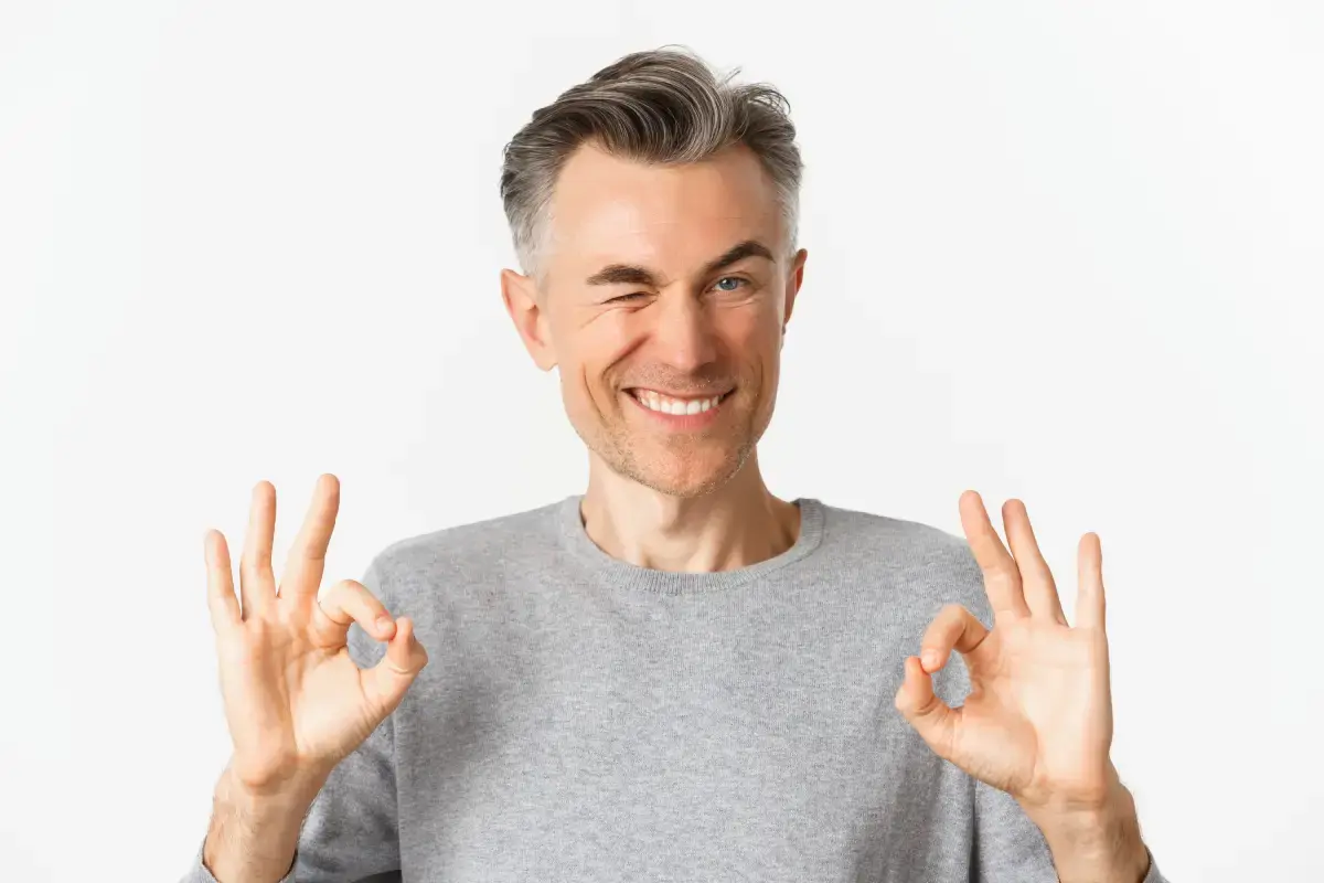Smiling man giving okay gesture approving dental crown treatment in Kernersville.