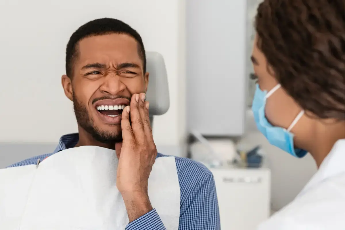 Man experiencing tooth pain during dental visit with dentist in Kernersville, NC.